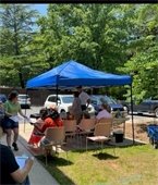 a group of people gather around a blue tent at RPL Headquarters to hear experts from Wild Birds Unlimited