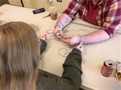 teens working together to create colorful plastic lace lanyards