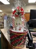 A holiday-themed gift basket wrapped in cellophane and marked for sale at RPL East