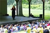 Milbre Burch performs for a large group of students and teachers in Sloan Park's outdoor amphitheater.