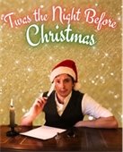 A man wearing a Santa hat holding a quill pen and sitting at a desk