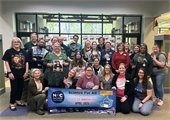 RPL staff pose for a group photo and hold up the NC Science Festival banner.