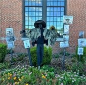 image of scarecrow display in a bed of flowers