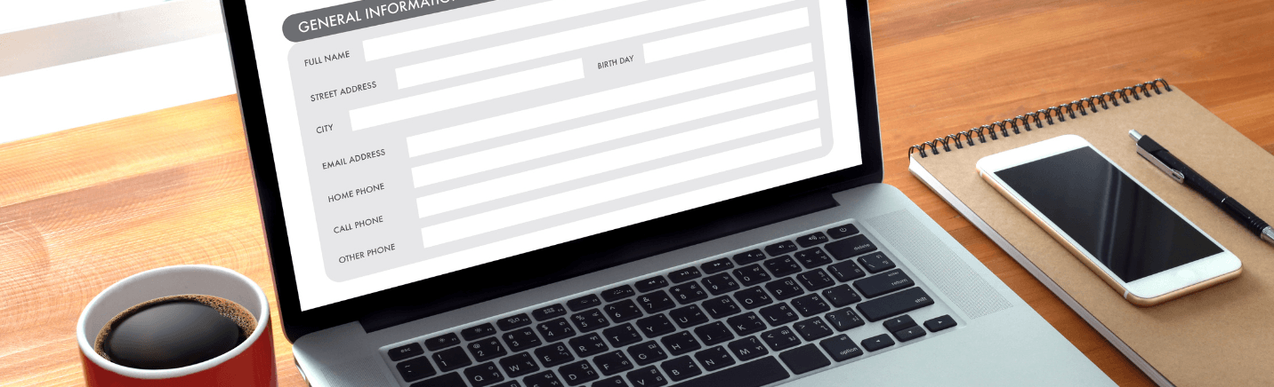 Laptop on a desk with a cup of coffee and an online form collecting general informatio