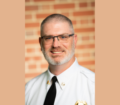 Male Emergency Services Employee standing in front of a brick wall