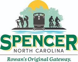 Silhouettes of hikers and cyclists flank a train under a yellow sun. Text reads: "Spencer North C